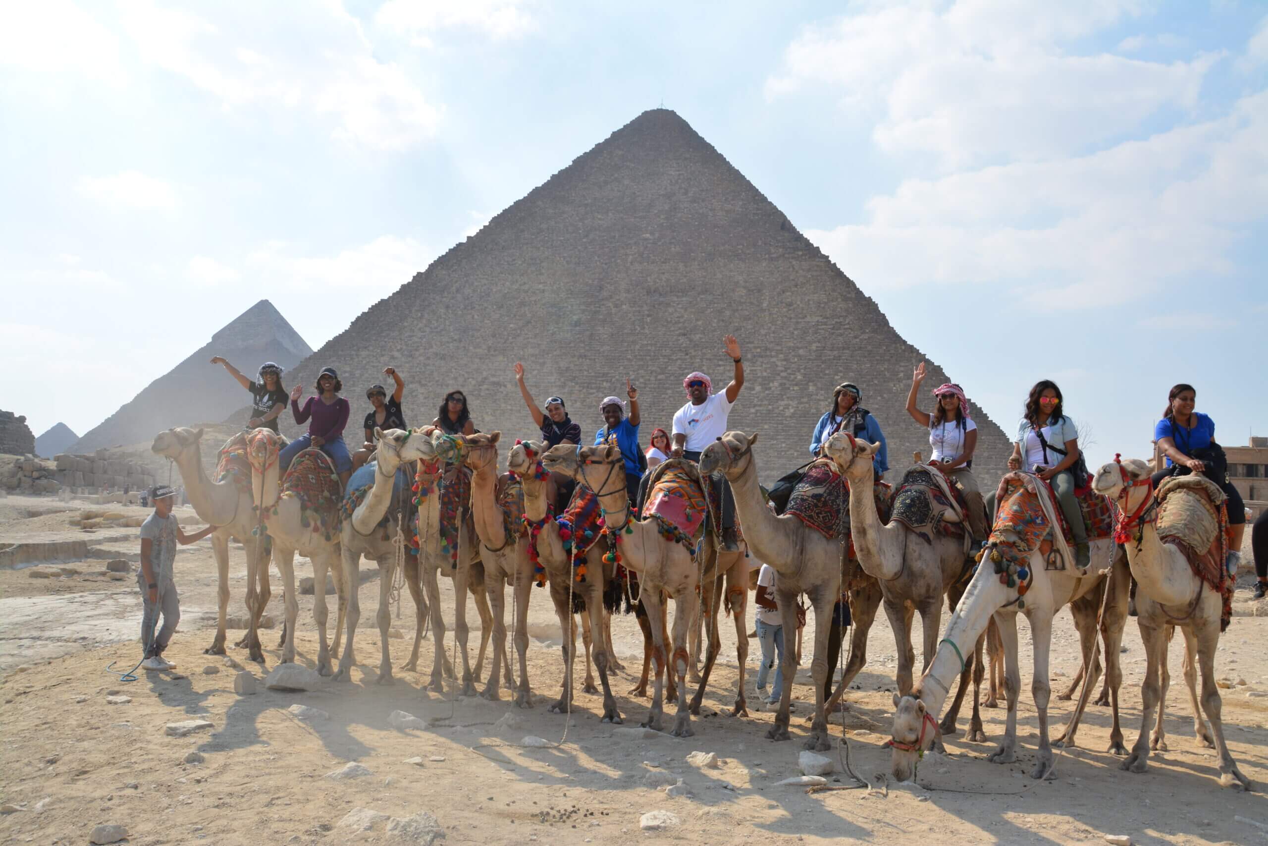 Group of people enjoying desert ride on camels
